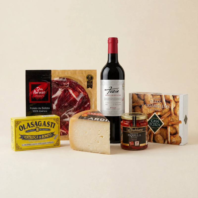 Cesta de Navidad con jamón ibérico, queso Idiazabal, ventresca, pimientos del piquillo, dulces y vino tinto.